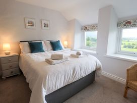 A bedroom with a bed and nightstand at Squirrel Cottage in Bassenthwaite