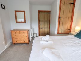 A bedroom with a bed and dresser at Squirrel Cottage in Bassenthwaite