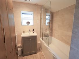 A bathroom with a bathtub and shower at Squirrel Cottage in Bassenthwaite