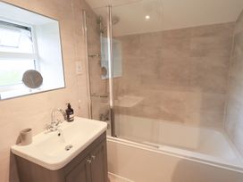 A bathroom with a shower and bathtub at Squirrel Cottage in Bassenthwaite