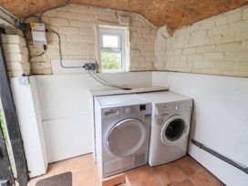 A laundry room with a washing machine and tumble dryer at Squirrel Cottage Bassenthwaite