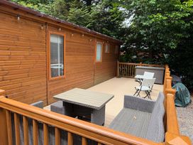 An outdoor area with a wooden cabin and seating at Cherry Tree Lodge, Calgarth 37, White Cross Bay near Windermere