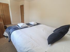 A bedroom with a bed and towels arranged at Ilgram in St Newlyn East