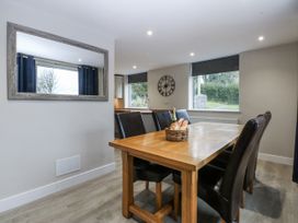 A dining room with a table and chairs at Caledfryn in Tyn-y-Gongl
