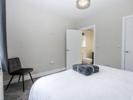 A bedroom with a chair and towels at Caledfryn Tyn-y-Gongl
