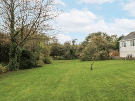 A garden with grass and trees at Caledfryn in Benllech