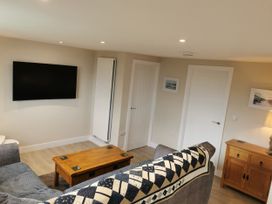 A living room with a television and coffee table at Caledfryn in Benllech