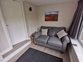 A living room with a sofa and cushions at Caledfryn in Benllech
