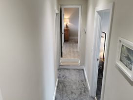 A hallway with carpet and a lamp at Caledfryn in Benllech