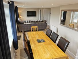 A dining room with a table and chairs at Caledfryn in Benllech