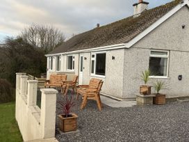 A house with chairs and planters at Caledfryn Benllech