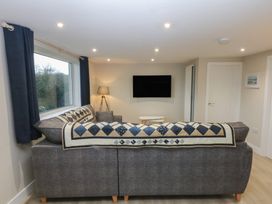 A living room with a sofa and television at Caledfryn in Benllech