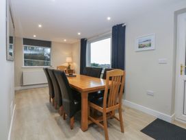 A dining room with a table and chairs at Caledfryn in Benllech