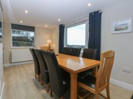 A dining room with a wooden table and chairs at Caledfryn in Benllech