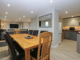 A dining room with a table and chairs at Caledfryn in Benllech