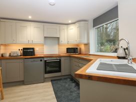 A kitchen with appliances and cabinets at Caledfryn in Benllech