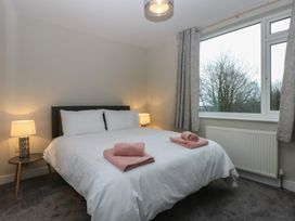 A bedroom with a bed and lamps at Caledfryn Benllech