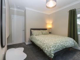 A bedroom with a bed and a lamp at Caledfryn in Benllech