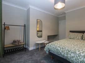 A bedroom with a bed and a mirror at Caledfryn in Benllech