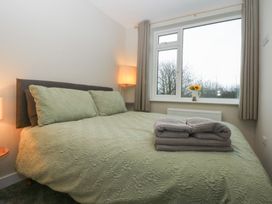 A bedroom with a bed and window at Caledfryn in Benllech