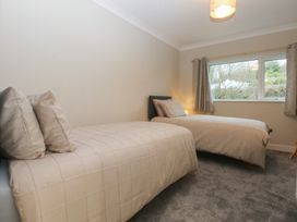 A bedroom with two beds and a window at Caledfryn in Benllech