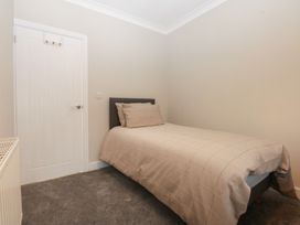 A bedroom with a bed and door at Caledfryn in Benllech