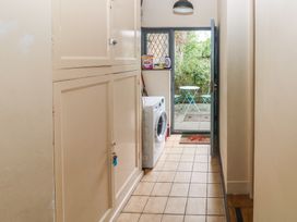 A laundry room with a washer and door leading to outdoor seating at Llys-Yr-Onnen in Carmarthen
