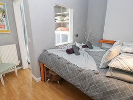 A bedroom with a bed and shelf at Llys-Yr-Onnen in Carmarthen