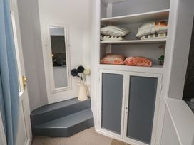 A hallway with a mirror and a shelf containing cushions at Llys-Yr-Onnen in Carmarthen