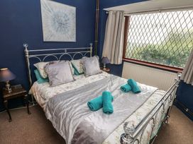 A bedroom with a bed and window at Llys-Yr-Onnen in Carmarthen
