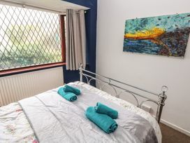 A bedroom with a bed and towels at Llys-Yr-Onnen in Carmarthen