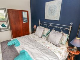 A bedroom with a bed and wardrobe at Llys-Yr-Onnen in Carmarthen