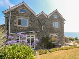 A house with stone exterior and windows overlooking the sea at Penmarth House Coverack