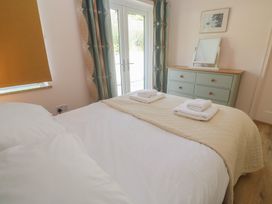 A bedroom with a bed and dresser at Penmarth House, Coverack