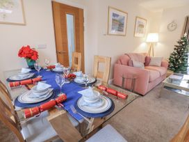 A dining room with a table set for a meal and a Christmas tree at Weydale Avenue Scarborough