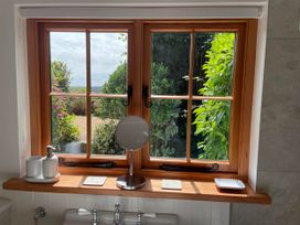 A bathroom with a window and a mirror at Bell Buoy Cottage in Morwenstow