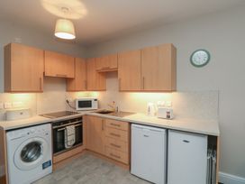 A kitchen with appliances including a washing machine, oven, and microwave at Beck View