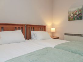 A bedroom with two beds and a bedside lamp at Beck View