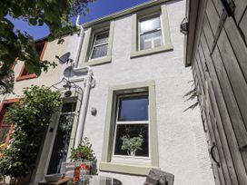 An exterior view of a cottage with plants and outdoor furniture at Hideaway Cottage in Penrith
