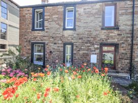 A garden with flowers outside a house at Hideaway Cottage in Penrith