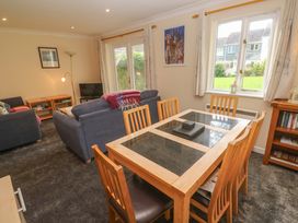A living room with a dining table and sofas at Pheasants Walk in Falmouth