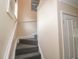 A staircase with a handrail and a painting on the wall at Pheasants Walk, Falmouth