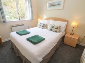 A bedroom with a bed and bedside table at Pheasants Walk in Falmouth