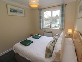 A bedroom with a bed and window at Pheasants Walk in Falmouth