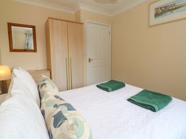 A bedroom with a bed, towels on it, a wardrobe and a mirror at Pheasants Walk in Falmouth