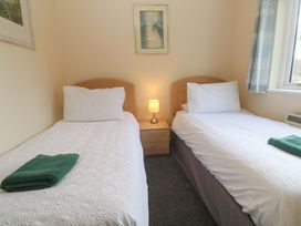 A bedroom with two single beds and a bedside lamp at Pheasants Walk Falmouth