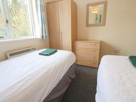 A bedroom with two beds and furniture at Pheasants Walk in Falmouth