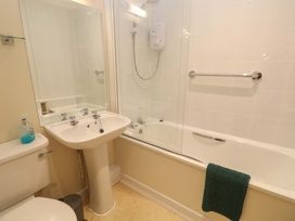 A bathroom featuring a bath tub, shower, wash basin, and toilet at Pheasants Walk in Falmouth