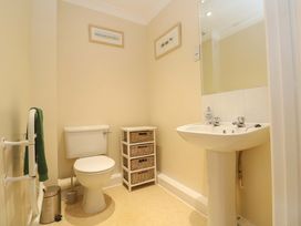 A bathroom with toilet, sink, and storage at Pheasants Walk in Falmouth