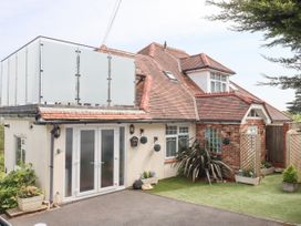 A residential house with a red tiled roof and white framed doors and windows at Flat 3 Channel View in Torquay